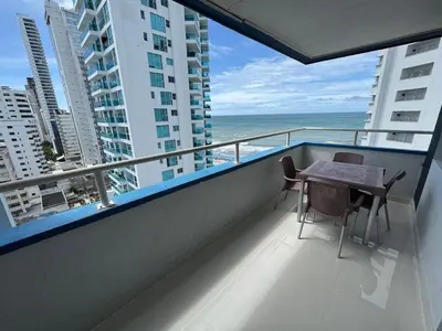 a balcony with a table and chairs and the ocean at Apartamento en Bocagrande con vista lateral al mar ICDI in Cartagena de Indias