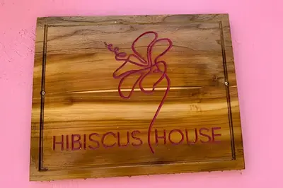 a wooden sign with aethos house with a red ribbon at Casa Hibiscus - Joya en Getsemani in Cartagena de Indias