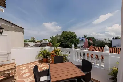 a balcony with a wooden table and chairs at Casa Hibiscus - Joya en Getsemani in Cartagena de Indias