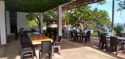 a restaurant with tables and chairs on a patio at Ecohotel Nativa Beach in Cartagena de Indias