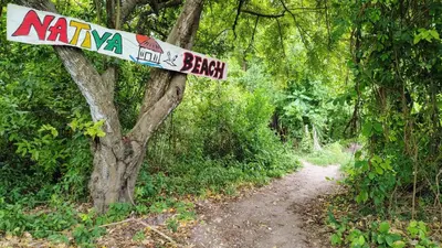 a sign on a trail in a forest at Ecohotel Nativa Beach in Cartagena de Indias