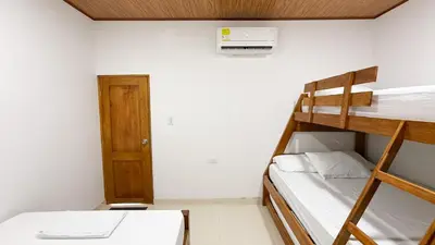 two bunk beds in a room with a door at Cabaña Datalu 3 in Coveñas