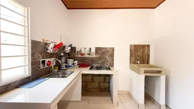 a white kitchen with a sink and a window at Cabaña Datalu 3 in Coveñas