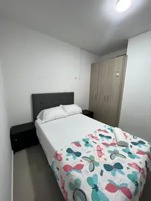 a bedroom with a bed with a flowered blanket at Rent by days, 4th floor apartment in Cartagena de Indias