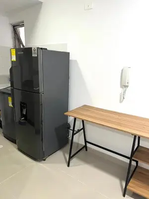 a black refrigerator next to a table and a phone at Rent by days, 4th floor apartment in Cartagena de Indias