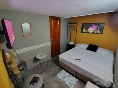 a bedroom with a bed and a table and a stool at Habitación Privada con Ventilador in Cartagena de Indias
