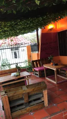 a patio with wooden benches and tables and a sign at Habitación Privada con Ventilador in Cartagena de Indias