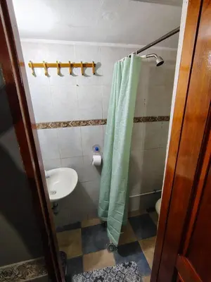 a bathroom with a green shower curtain and a sink at Habitación Privada con Ventilador in Cartagena de Indias