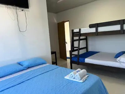 a bedroom with two bunk beds with towels and a television at Hotel mirador Dubai in San Antero