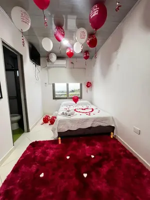 a bedroom with red balloons and a bed with a red rug at Hotel mirador Dubai in San Antero