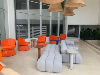 a lobby with orange and white chairs and tables at Oceani Towers 1006 in Cartagena de Indias