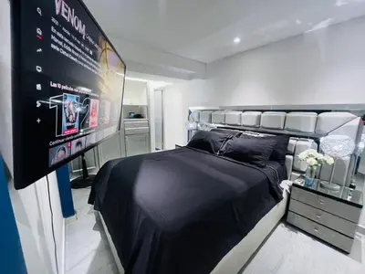 a room with a bed and a large screen at Apartaestudio Cielo Mar A 100 Mts playa - Al Frente Hotel Las Americas in Cartagena de Indias