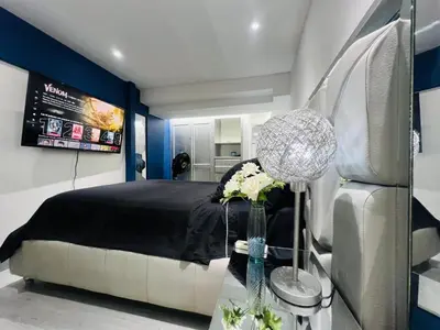 a bedroom with a black bed and blue walls at Apartaestudio Cielo Mar A 100 Mts playa - Al Frente Hotel Las Americas in Cartagena de Indias