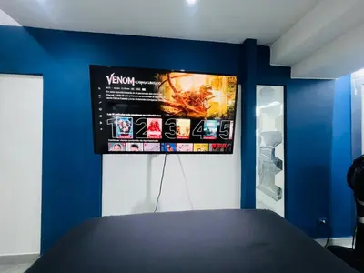a room with a tv on a blue wall at Apartaestudio Cielo Mar A 100 Mts playa - Al Frente Hotel Las Americas in Cartagena de Indias