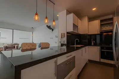 a kitchen with white cabinets and black counter tops at Espectacular vista al mar - Infinito 2502 in Cartagena de Indias