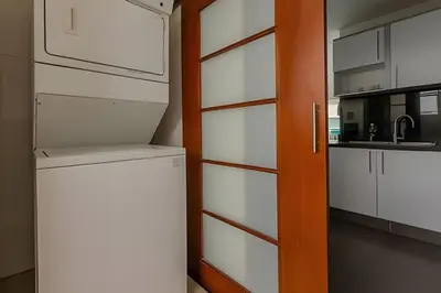 a kitchen with white cabinets and a refrigerator at Espectacular vista al mar - Infinito 2502 in Cartagena de Indias