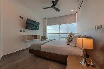 a bedroom with a large bed with a large window at Espectacular vista al mar - Infinito 2502 in Cartagena de Indias