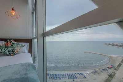a bedroom with a large window with a view of the ocean at Espectacular vista al mar - Infinito 2502 in Cartagena de Indias