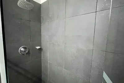 a bathroom with a shower with a tile wall at Infinitum Spectacular 23rd floor 1 BR Condo in Cartagena de Indias