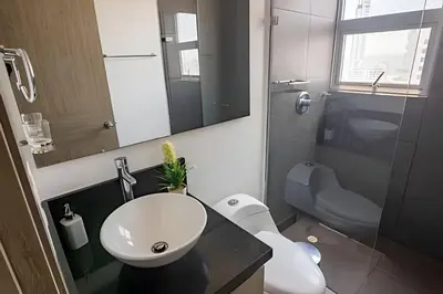 a bathroom with a sink and a toilet and a mirror at Lujoso Apto de 2 habitaciones en piso 23-Infinitum in Cartagena de Indias