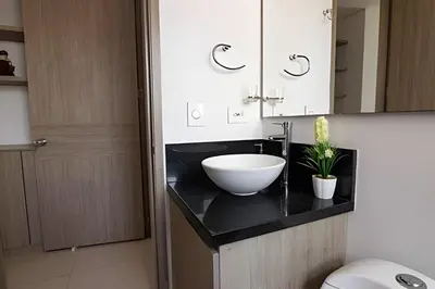 a bathroom with a bowl sink on a black counter at Lujoso Apto de 2 habitaciones en piso 23-Infinitum in Cartagena de Indias