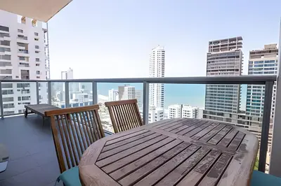 a balcony with a wooden table and chairs at Lujoso Apto de 2 habitaciones en piso 23-Infinitum in Cartagena de Indias