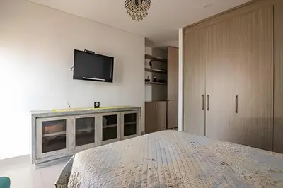 a bedroom with a bed and a tv on a wall at Lujoso Apto de 2 habitaciones en piso 23-Infinitum in Cartagena de Indias