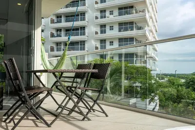 two chairs sitting on the balcony of a building at Modern apt near the beach with Jacuzzi, Cartagena in Cartagena de Indias