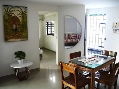 a dining room with a table and chairs and a mirror at Comfortable and quiet apartment in Cartagena de Indias