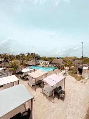 a resort with tables and a swimming pool at Margarita's Beach Club in Playa Punta Arena