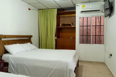 a bedroom with two beds and a door with a window at Donde Mire in Puerto Colombia
