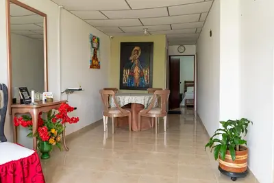 a dining room with a table and chairs and a painting at Donde Mire in Puerto Colombia