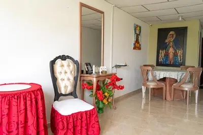 a room with a table and chairs and a table with flowers at Donde Mire in Puerto Colombia