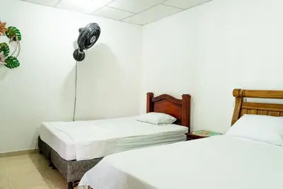 two beds in a room with white walls at Donde Mire in Puerto Colombia