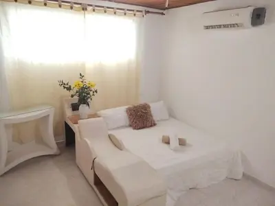 a white bedroom with a white couch and a window at Apartamento en Manga cerca al Centro Historico in Cartagena de Indias