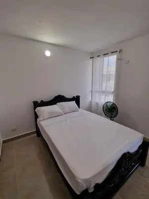 a bedroom with a bed with white sheets and a window at Apartamento en Cartagena, Manzanillo in La Siriaca