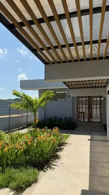 a building with a wooden pergola and some plants at Apartamento en Cartagena, Manzanillo in La Siriaca