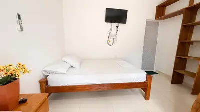 a small bedroom with a bed and a tv at Cabaña Datalu 2 in Coveñas