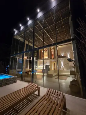 a building with a bench and a swimming pool at night at Lotus Beach House playa privada in San Silvestre