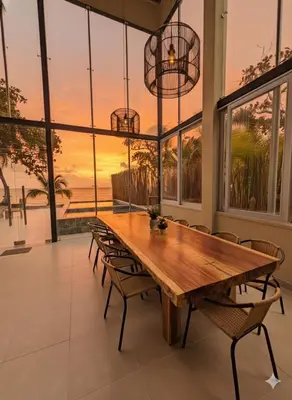 a dining room with a wooden table and chairs at Lotus Beach House playa privada in San Silvestre