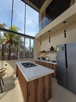 a kitchen with a refrigerator and a counter top at Lotus Beach House playa privada in San Silvestre