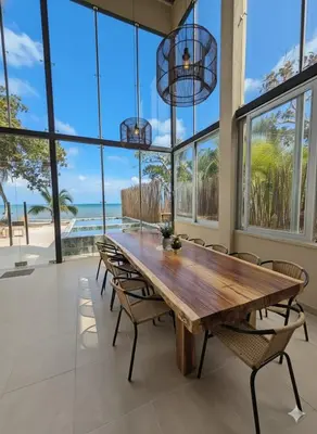 a large dining room with a wooden table and chairs at Lotus Beach House playa privada in San Silvestre
