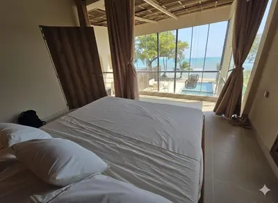 a bed in a bedroom with a view of the ocean at Lotus Beach House playa privada in San Silvestre