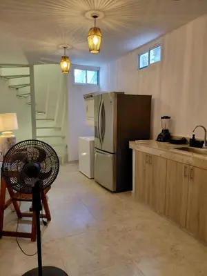 a kitchen with a refrigerator and a table and a chair at Oasis Colonial Cartagena in Cartagena de Indias