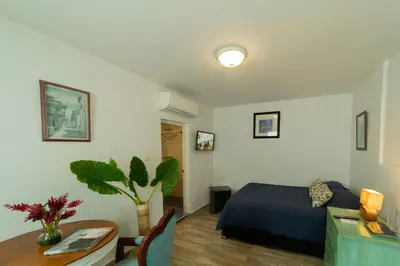 a bedroom with a bed and a desk and a table with a table at Oasis Colonial Cartagena in Cartagena de Indias