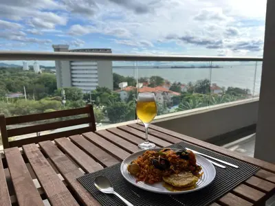 a plate of food and a glass of wine on a table at Santa Marta apartamento con vista al mar- santamarina-709 in Santa Marta