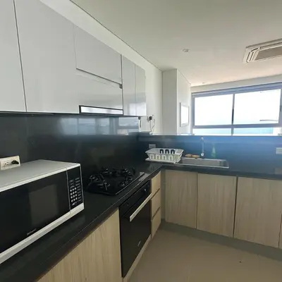 a kitchen with a microwave and a stove top oven at by Calamari Homes - Murano Elite 1901 Bocagrande in Cartagena de Indias