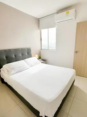 a large white bed in a room with a window at Moderno apto a pasos de la playa in Cartagena de Indias