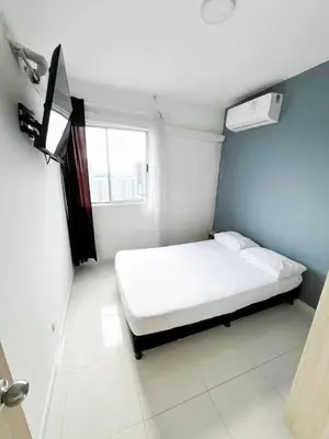 a small room with a bed and a window at Moderno apto a pasos de la playa in Cartagena de Indias