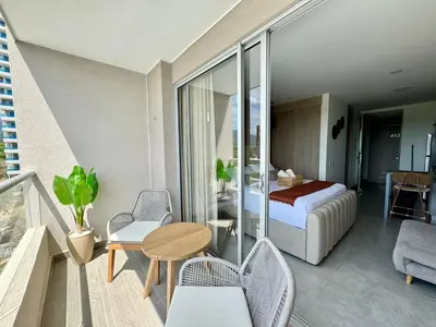 a bedroom with a balcony with a bed and a table at Apartamento cerca al mar santa Marta- santamarina-614 in Santa Marta